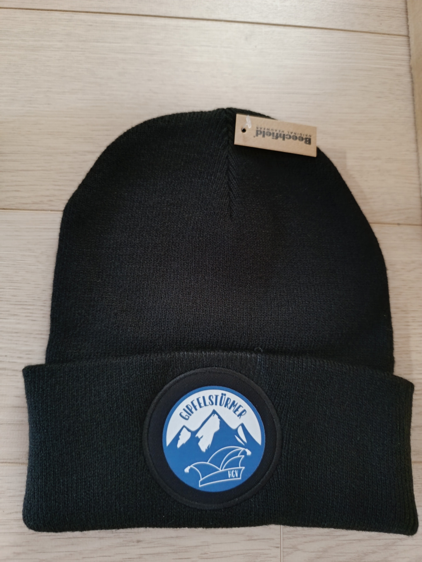 Schwarze Beanie-Mütze mit gesticktem Aufnäher