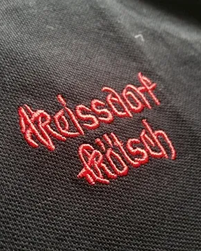 Rot gestickter Schriftzug auf dunklem Poloshirt