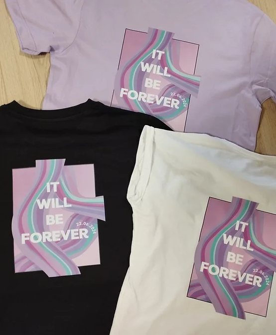 Drei T-Shirts in Flieder, Schwarz und Creme mit großflächigem Farbdruck